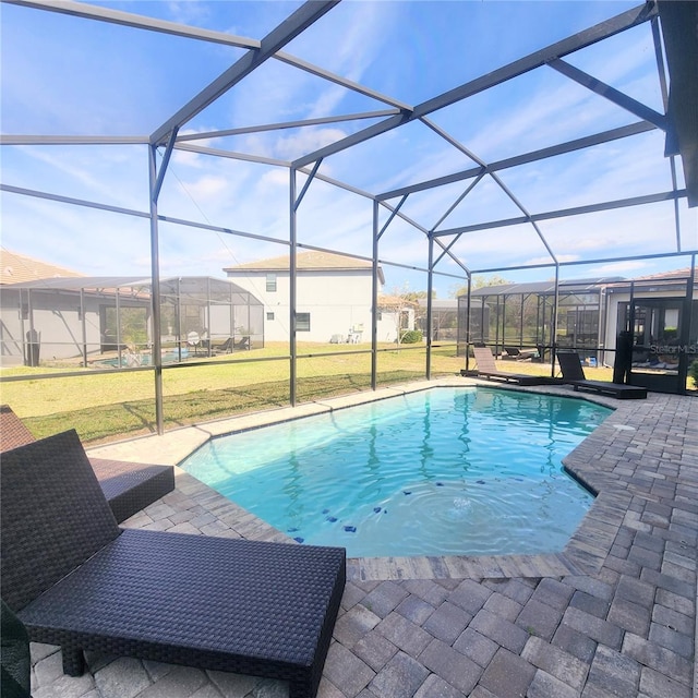 view of swimming pool featuring a yard, a patio area, and a lanai