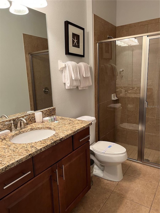 bathroom with toilet, a shower stall, and vanity