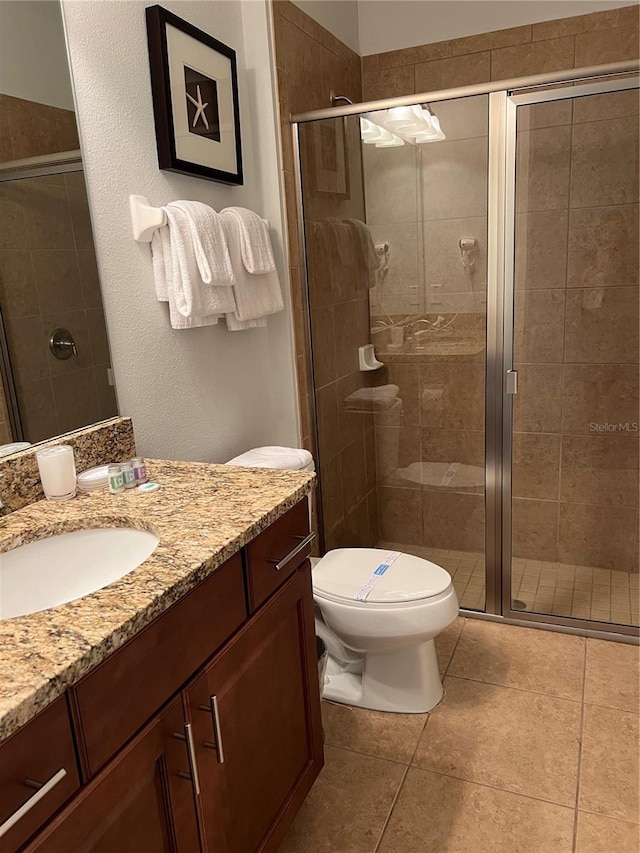 full bath featuring toilet, a stall shower, tile patterned floors, and vanity