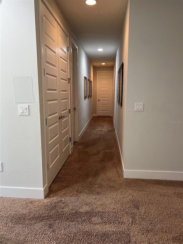 hall with dark colored carpet, recessed lighting, and baseboards