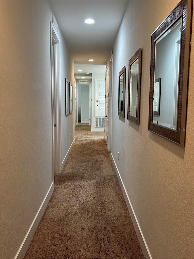 corridor with carpet floors, visible vents, baseboards, and recessed lighting