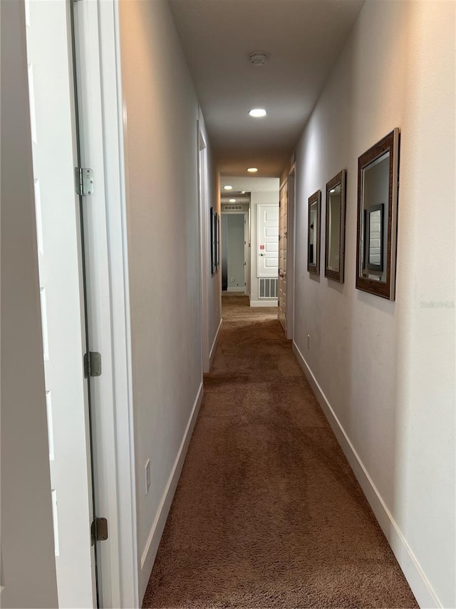 corridor featuring baseboards, visible vents, dark carpet, and recessed lighting