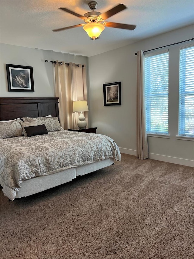 bedroom featuring carpet floors, a textured ceiling, baseboards, and a ceiling fan