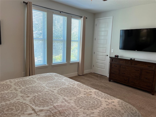 bedroom featuring light colored carpet and baseboards