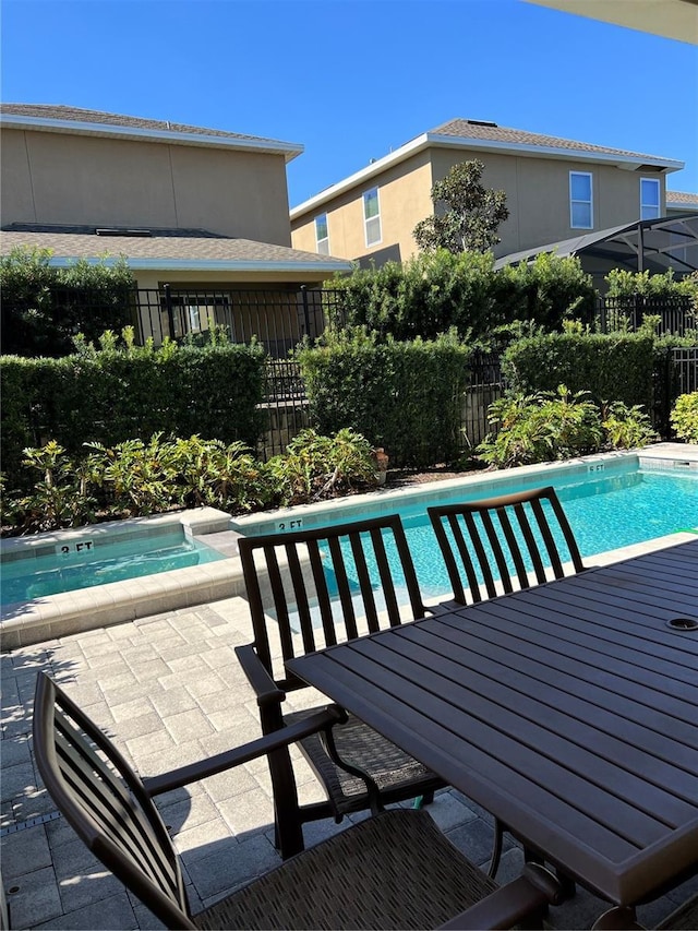 view of pool with a hot tub, fence, and a fenced in pool