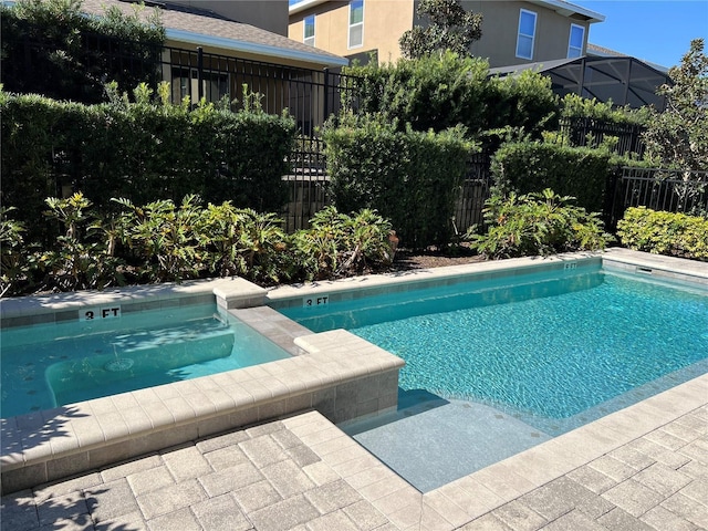 view of pool with fence and an in ground hot tub