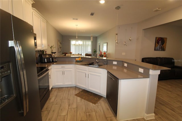 kitchen with kitchen peninsula, appliances with stainless steel finishes, light wood-type flooring, sink, and white cabinetry