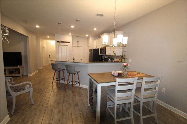 dining space featuring a chandelier and dark wood-type flooring