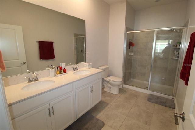 bathroom with tile patterned flooring, vanity, toilet, and an enclosed shower