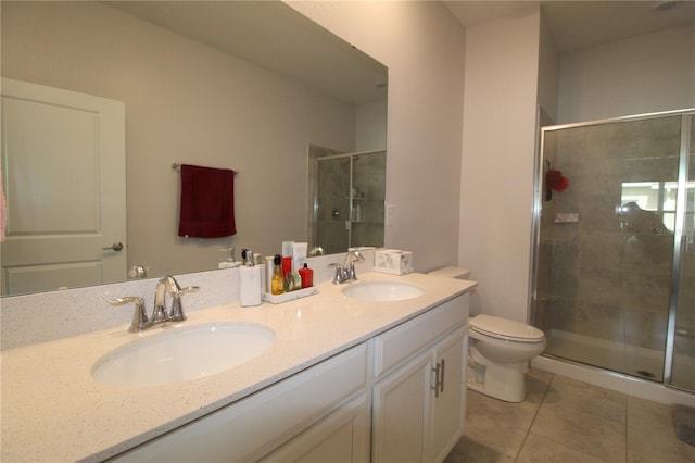 bathroom featuring tile patterned floors, vanity, a shower with shower door, and toilet