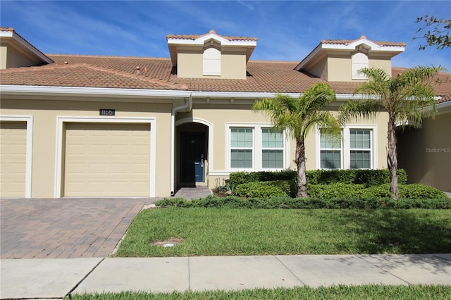 mediterranean / spanish-style house with a front lawn and a garage