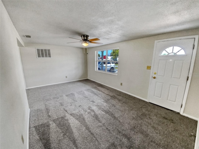 foyer entrance featuring plenty of natural light, dark carpet, and ceiling fan