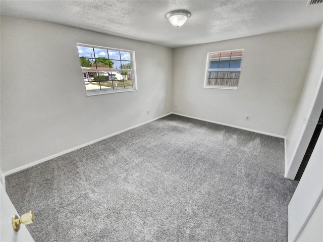 carpeted spare room featuring a textured ceiling