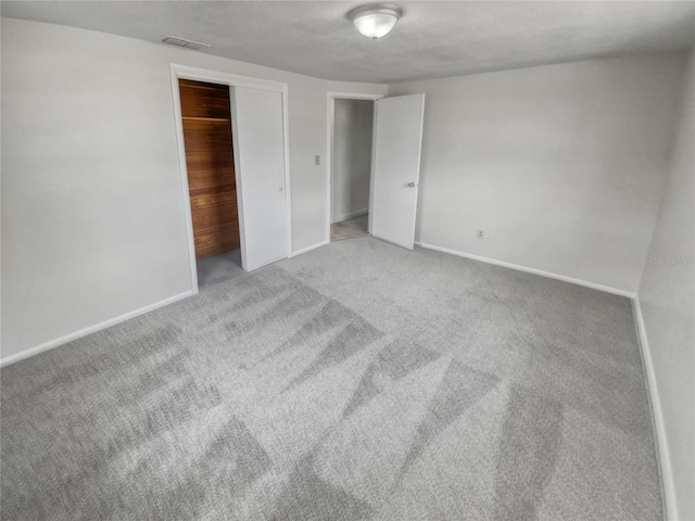 unfurnished bedroom with light carpet and a closet