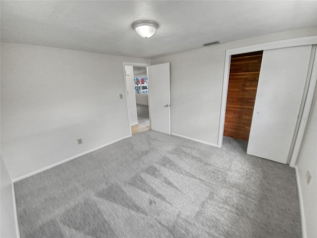 unfurnished bedroom featuring light carpet and a closet