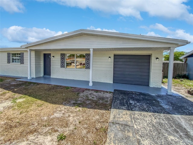 ranch-style home with covered porch and a garage