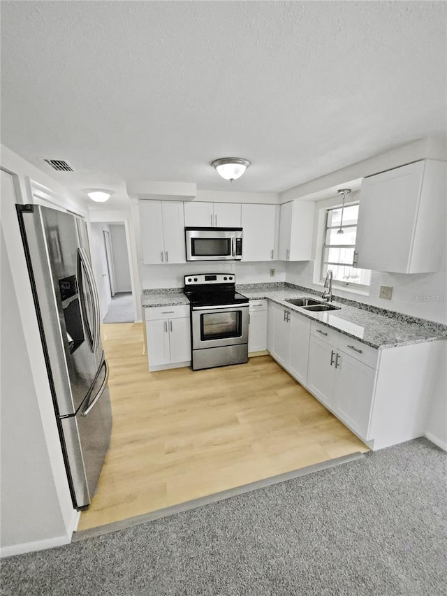 kitchen featuring white cabinets, light wood-type flooring, sink, and stainless steel appliances