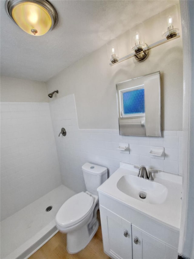 bathroom with tile walls, toilet, backsplash, large vanity, and hardwood / wood-style flooring