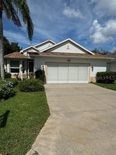 single story home featuring a garage and a front lawn