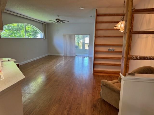 living room with plenty of natural light, ceiling fan, and dark hardwood / wood-style floors