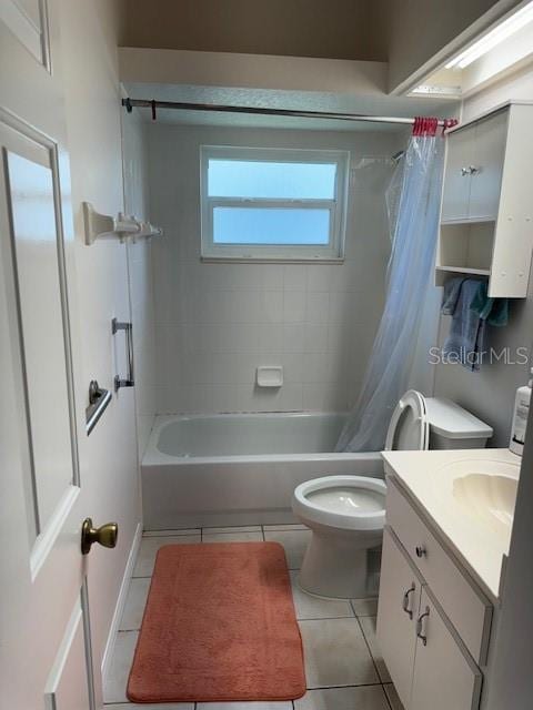 full bathroom with vanity, toilet, shower / bath combo with shower curtain, and tile patterned flooring