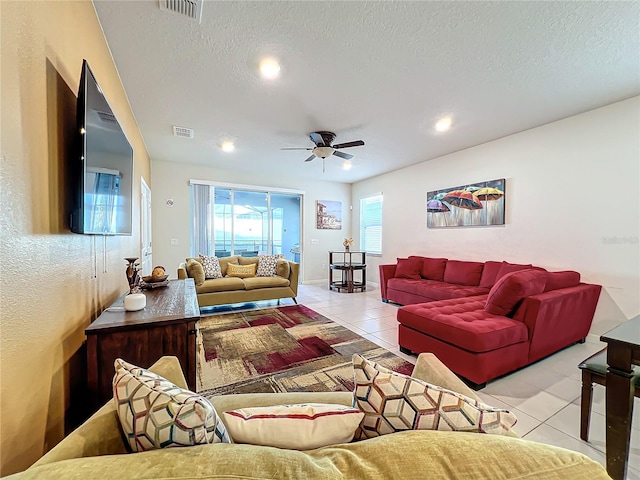 tiled living room featuring ceiling fan and a textured ceiling