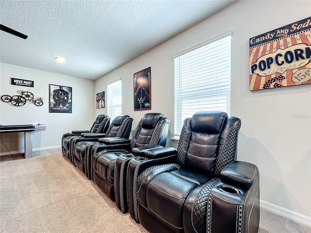 carpeted home theater featuring a textured ceiling and a wealth of natural light