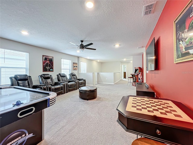 game room featuring light carpet, a textured ceiling, and ceiling fan