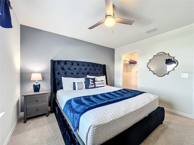 carpeted bedroom featuring ceiling fan, a walk in closet, and a closet