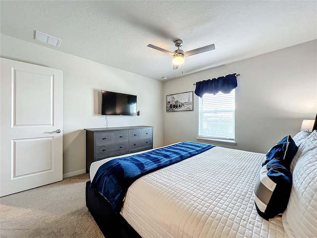 bedroom featuring light carpet, a textured ceiling, and ceiling fan