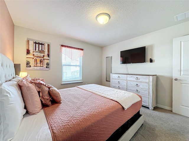 carpeted bedroom featuring a textured ceiling