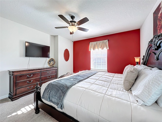 bedroom with light carpet, a textured ceiling, and ceiling fan