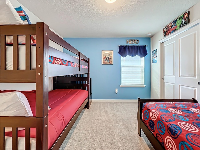 bedroom featuring a textured ceiling and light colored carpet