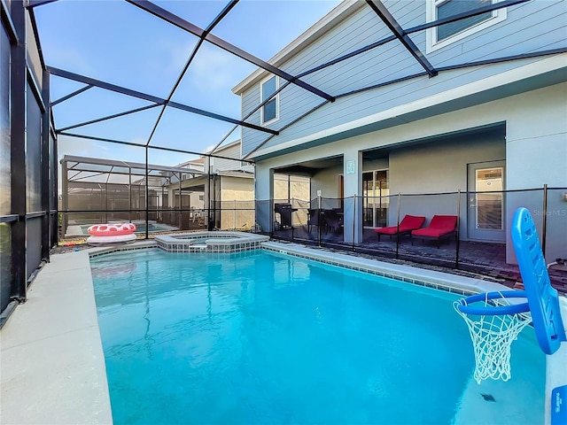 view of pool with a patio, an in ground hot tub, and glass enclosure