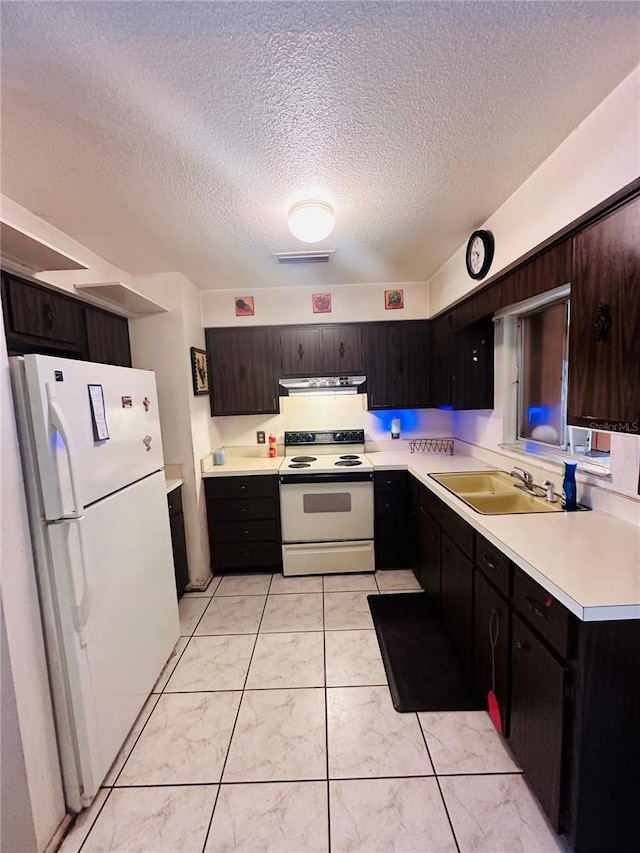 kitchen with dark brown cabinetry, a textured ceiling, sink, and white appliances