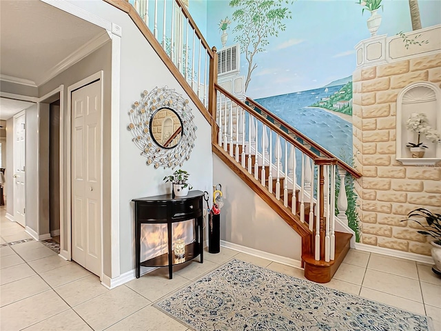 staircase with ornamental molding and light tile floors