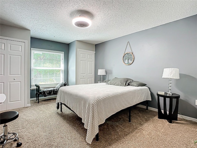 bedroom with a textured ceiling and light colored carpet