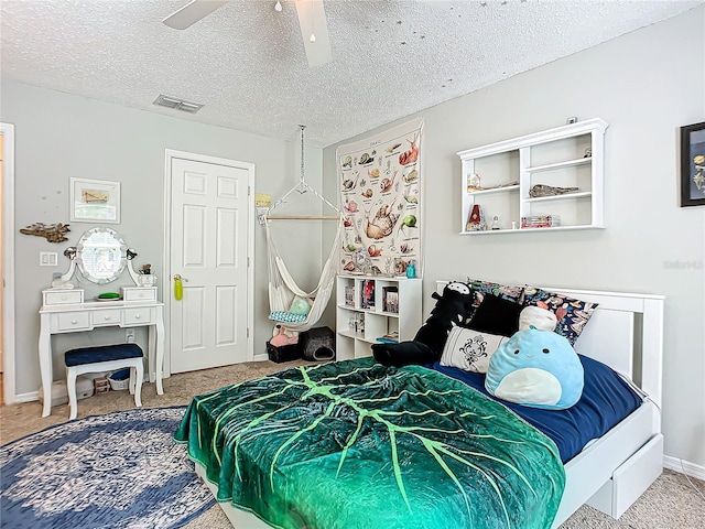 carpeted bedroom featuring a textured ceiling and ceiling fan