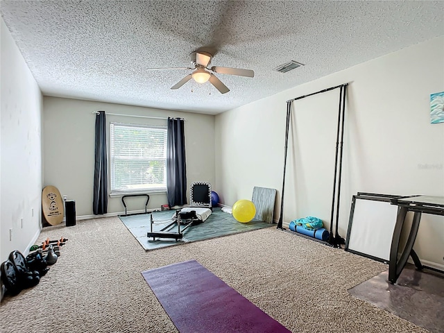 exercise room featuring a textured ceiling, ceiling fan, and carpet floors