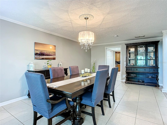 tiled dining space with a textured ceiling, ornamental molding, and a notable chandelier