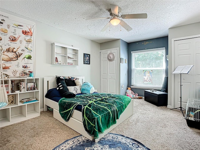 bedroom with light carpet, ceiling fan, and a textured ceiling