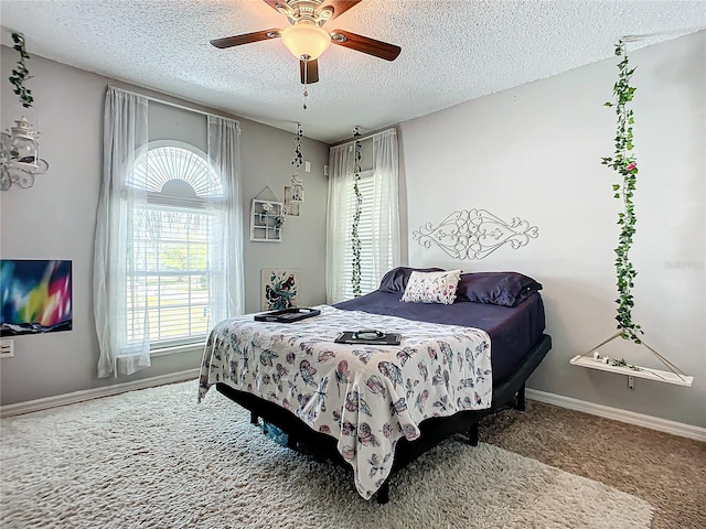 carpeted bedroom featuring a textured ceiling and ceiling fan