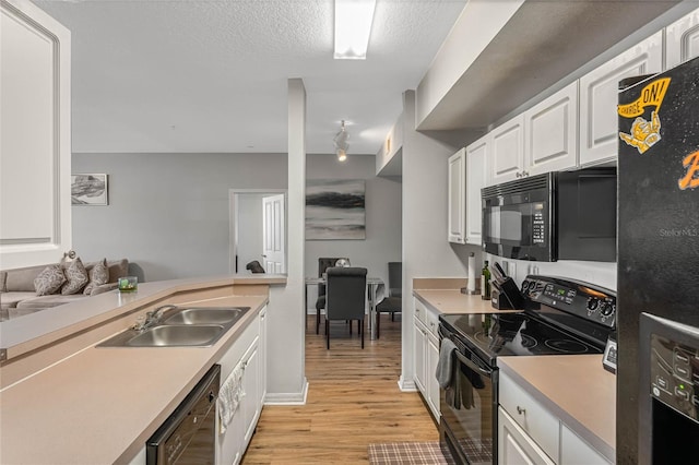 kitchen with white cabinetry, sink, a textured ceiling, black appliances, and light wood-type flooring