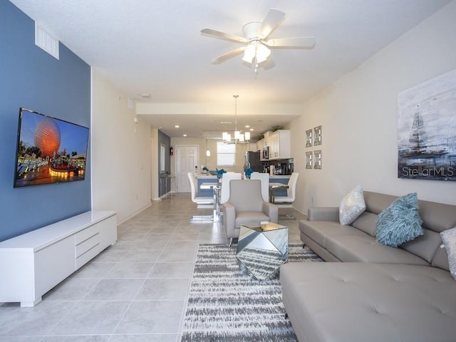 living room featuring light tile patterned flooring and ceiling fan with notable chandelier