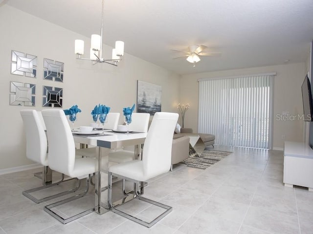 tiled dining space featuring ceiling fan with notable chandelier