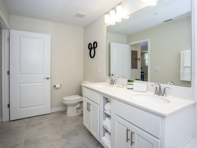 bathroom featuring toilet, double sink vanity, and tile patterned floors