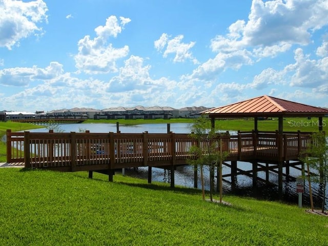 view of dock featuring a gazebo, a water view, and a lawn