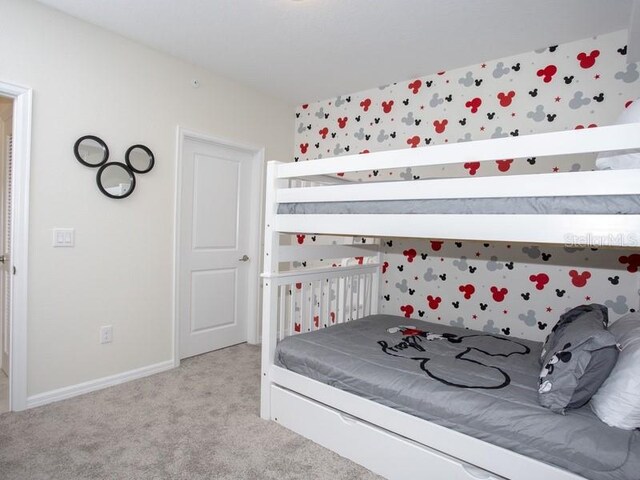 bedroom with light carpet and baseboards