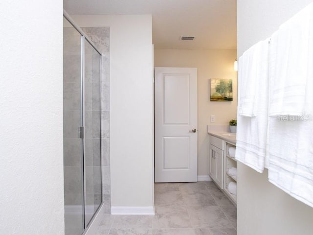 bathroom featuring tile patterned flooring, vanity, and a shower with shower door