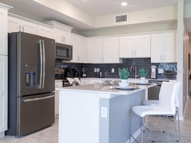 kitchen with a center island, stainless steel appliances, and white cabinets